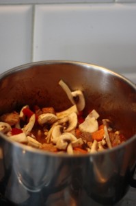 Gulasz z szynki z pieczarkami, papryką i marchewką przygotowywany w garnku