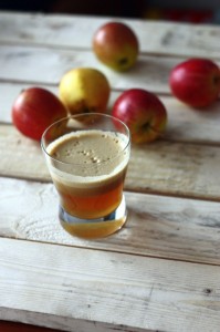 Naturalny sok jabłkowy, kilka jabłek w tle